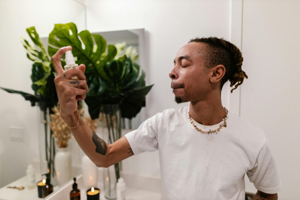 Joven aplicando tonico , haciendo su limpieza facial en casa.